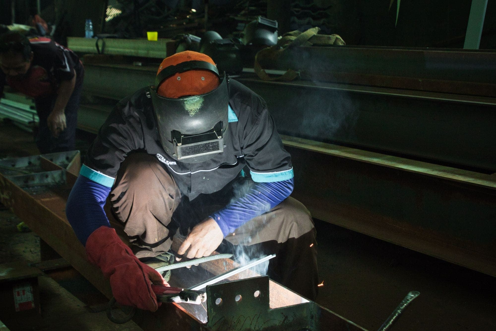 Welder working on steel structures in a workshop